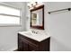 Bathroom vanity with dark wood cabinets, modern faucet, and large framed mirror at 3975 Denwood Dr, Indianapolis, IN 46226