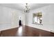 Inviting dining room featuring hardwood floors, a classic chandelier, wainscoting, and sunlit windows at 3975 Denwood Dr, Indianapolis, IN 46226