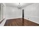 Elegant dining room with gleaming hardwood floors, wainscoting, a chandelier, and abundant natural light at 3975 Denwood Dr, Indianapolis, IN 46226