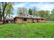 Lovely brick home with a chimney, solar panels, and lush green yard, offering a blend of classic charm at 3975 Denwood Dr, Indianapolis, IN 46226