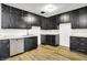 Spacious kitchen featuring black cabinets and stainless steel dishwasher with laminate flooring at 3975 Denwood Dr, Indianapolis, IN 46226