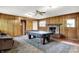 Retro living room featuring wood paneling, fireplace, and a pool table at 3975 Denwood Dr, Indianapolis, IN 46226