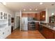 Kitchen with stainless steel appliances and wood cabinets and flooring at 4281 Cairo Way, Avon, IN 46123