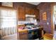 Kitchen features stainless steel stove and dark wood cabinetry with brick accent wall at 4429 Iowa St, Clayton, IN 46118