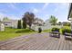 Expansive backyard view with a wooden deck, lush green grass, and a white fence at 4615 Copper Grove Dr, Indianapolis, IN 46237