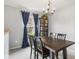 Bright dining area features a dark wood table, black chairs, and blue curtains at 4615 Copper Grove Dr, Indianapolis, IN 46237