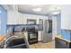Well-lit kitchen with stainless steel refrigerator, sleek black oven, and white cabinets at 4615 Copper Grove Dr, Indianapolis, IN 46237