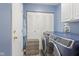 Well-lit laundry room featuring blue front-load washer and dryer, plus storage at 4615 Copper Grove Dr, Indianapolis, IN 46237
