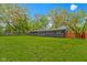 Spacious backyard showcasing a gray house with a well-maintained lawn and a wooden fence at 4720 E 42Nd St, Indianapolis, IN 46226