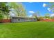 The back of house features siding, a green backyard, and a wooden fence at 4720 E 42Nd St, Indianapolis, IN 46226