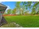 Expansive backyard features lush green grass with a wooden fence, and mature trees at 4720 E 42Nd St, Indianapolis, IN 46226
