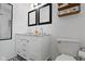 Well-lit bathroom with double sinks, modern fixtures, a clean design, and a black and white tiled floor at 4720 E 42Nd St, Indianapolis, IN 46226