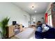 Spacious living room featuring a blue sofa, wood floors, a modern entertainment center, and natural light at 4720 E 42Nd St, Indianapolis, IN 46226
