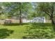 Backyard view with a white house, garage, wooden fence, and verdant lawn at 4721 E Morris St, Indianapolis, IN 46203