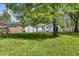 Backyard view with a white house, garage, wooden fence, and lots of green space at 4721 E Morris St, Indianapolis, IN 46203