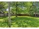 Lush backyard with a tall wooden privacy fence and mature trees offering shade at 4721 E Morris St, Indianapolis, IN 46203