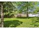 Fenced yard offering privacy, complemented by green grass and trees, creating a serene outdoor space at 4721 E Morris St, Indianapolis, IN 46203