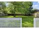 Spacious fenced backyard view from the deck, surrounded by mature trees offering ample privacy at 4721 E Morris St, Indianapolis, IN 46203