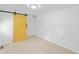 Bedroom featuring a unique yellow barn door, carpet, and a neutral color palette at 4721 E Morris St, Indianapolis, IN 46203
