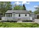 Charming single-story home with a white picket fence, lush green lawn, and detached garage at 4721 E Morris St, Indianapolis, IN 46203