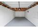 An empty garage with an unfinished ceiling and painted walls and floor at 4721 E Morris St, Indianapolis, IN 46203