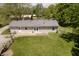 Aerial view of backyard featuring a well-maintained lawn, patio, mature trees, and partial fence at 503 E Bunker Hill Rd, Mooresville, IN 46158