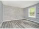 Gray room with wood-look floors and accent wall, showing off the neutral design at 503 E Bunker Hill Rd, Mooresville, IN 46158