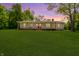 Charming home with a well-manicured lawn, covered porch with a swing, and a vibrant red front door at sunset at 503 E Bunker Hill Rd, Mooresville, IN 46158