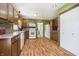 Traditional eat-in kitchen features wood cabinets, backsplash, white appliances, and a wood-look laminate floor at 503 E Bunker Hill Rd, Mooresville, IN 46158