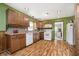Traditional eat-in kitchen features wood cabinets, backsplash, white appliances, and a wood-look laminate floor at 503 E Bunker Hill Rd, Mooresville, IN 46158