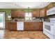 Well-lit kitchen with wooden cabinets, modern appliances, and a mosaic backsplash complementing the green wall paint at 503 E Bunker Hill Rd, Mooresville, IN 46158