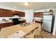 Well-lit kitchen showcases brown cabinets, black appliances, and an island with barstool seating at 5313 Brandywine Dr, Whitestown, IN 46075