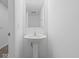 A pedestal sink in a bright half-bath exudes simple elegance with modern fixtures at 558 Plowman Dr, Shelbyville, IN 46176