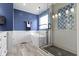 Luxury bathroom with stand alone tub, glass shower, blue accent wall, and mosaic tile at 5593 Ralfe Rd, Indianapolis, IN 46234