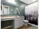 Neutral colored bathroom with large vanity, sink, toilet, and shower with curtain at 5593 Ralfe Rd, Indianapolis, IN 46234
