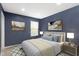Stylish bedroom with blue walls, large window, and calming, neutral colored bedding at 5593 Ralfe Rd, Indianapolis, IN 46234