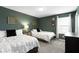 Comfortable bedroom with two beds, soft carpet, dark accent wall, and natural light at 5593 Ralfe Rd, Indianapolis, IN 46234
