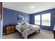 Comfortable bedroom with white comforter, natural light, and a cool blue painted wall at 5593 Ralfe Rd, Indianapolis, IN 46234