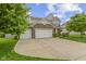 Lovely two-story home featuring stone accents, a three-car garage, a wide driveway, and green landscaping at 5593 Ralfe Rd, Indianapolis, IN 46234