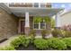 Inviting front porch with stone accents, ferns hanging, a 'Welcome' sign, and fresh landscaping at 5593 Ralfe Rd, Indianapolis, IN 46234