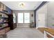 Open-concept living area features built-in shelving, gray carpet, and natural light from two windows at 5593 Ralfe Rd, Indianapolis, IN 46234
