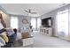 Sun-filled living room features plush carpet, ceiling fan, stylish furnishings, and streaming sunlight at 5593 Ralfe Rd, Indianapolis, IN 46234