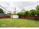 Spacious backyard with a well-maintained lawn, wooden fence, and a white storage shed at 5605 Glencoe St, Indianapolis, IN 46226