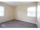Carpeted bedroom featuring a neutral color and two windows for natural light, perfect for comfort at 5605 Glencoe St, Indianapolis, IN 46226