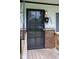 Close-up of front door with security screen and mailbox, set against a brick facade at 5605 Glencoe St, Indianapolis, IN 46226
