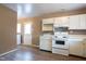 Efficient kitchen layout with white cabinets, modern stove, and easy access to laundry area at 5605 Glencoe St, Indianapolis, IN 46226