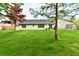 Expansive backyard features a well-manicured lawn and mature trees at 5611 Burning Tree Ct, Indianapolis, IN 46239