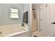 Bathroom featuring a soaking tub, stand up shower, window for natural light, and white walls at 5611 Burning Tree Ct, Indianapolis, IN 46239