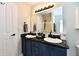 Bathroom with dual sinks, a dark countertop, ample lighting, and modern fixtures at 5611 Burning Tree Ct, Indianapolis, IN 46239