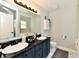 Bathroom features a dual sink vanity with a dark countertop, decorative lighting, and a mirror at 5611 Burning Tree Ct, Indianapolis, IN 46239